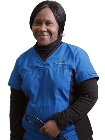 Nursing student in blue scrubs holding a stethoscope