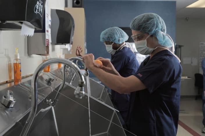 Nursing students wearing personal protection equipment and washing their hands