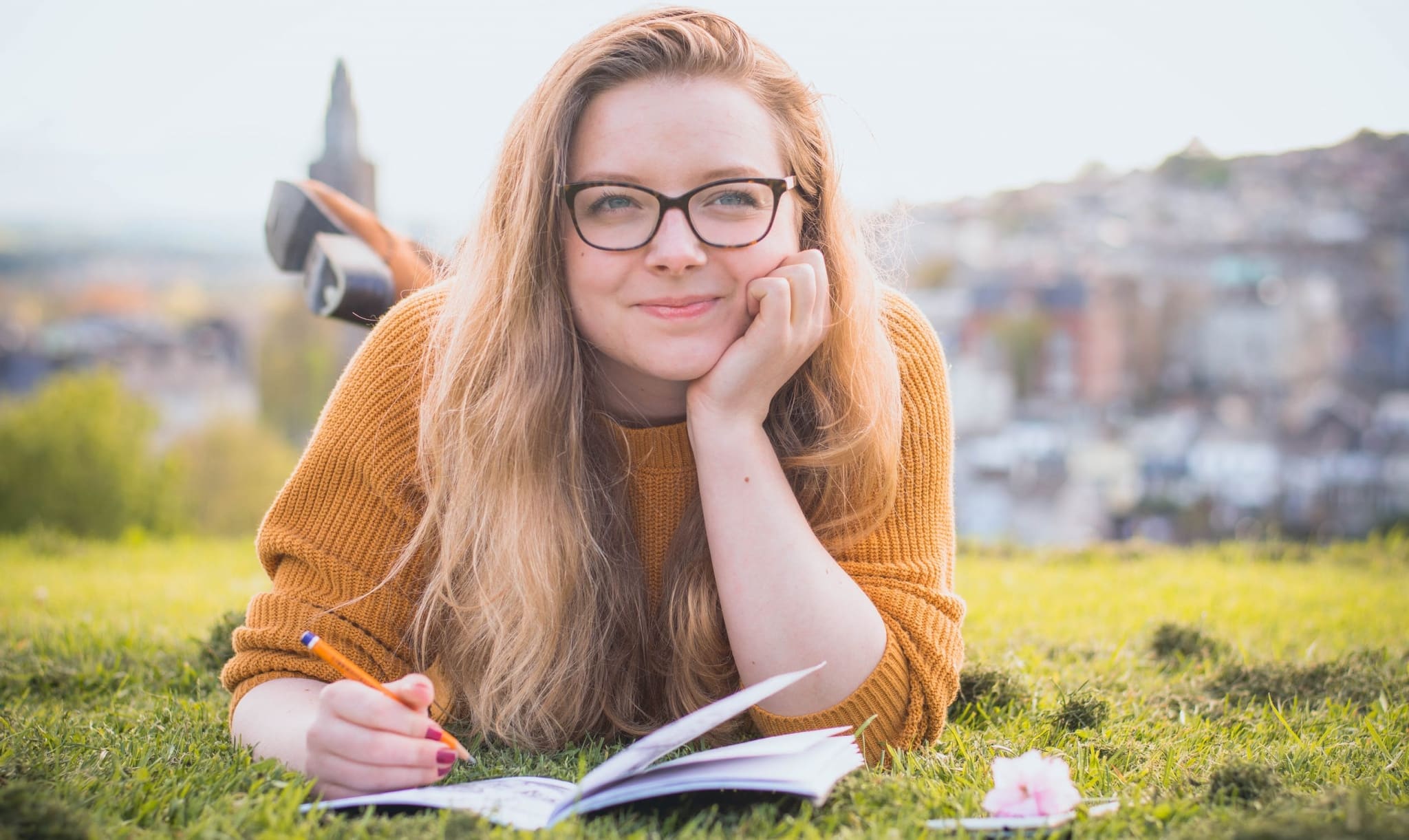 Smiling woman writing outside