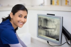 Trabajador dental sonriente con una radiografía