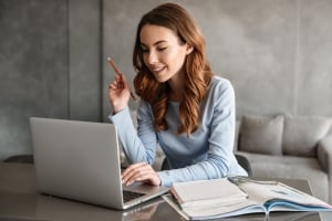 Mujer en un portátil tomando notas