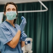 Smiling nurse in scrubs and a mask