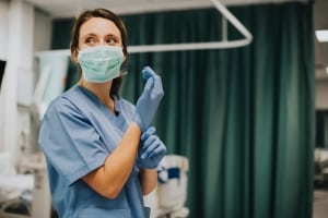 Smiling nurse in scrubs and a mask