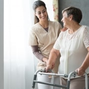 Caregiver helping a patient use her walker