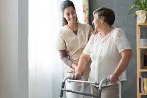 Caregiver helping a patient use her walker