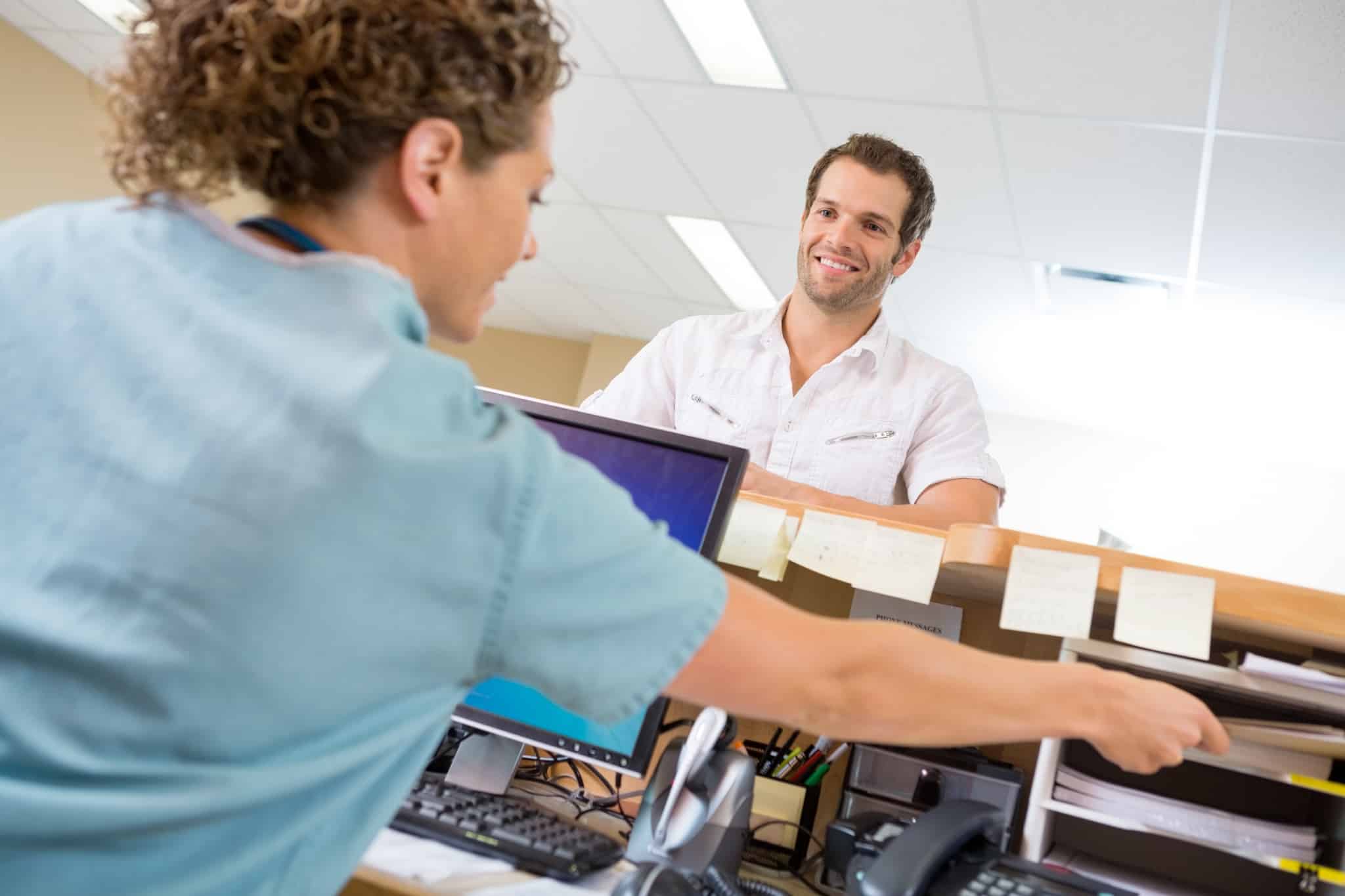 Medical receptionist helping a male patient
