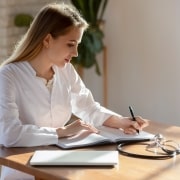 Medical professional writing in a notebook