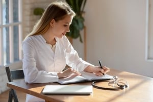 Medical professional writing in a notebook