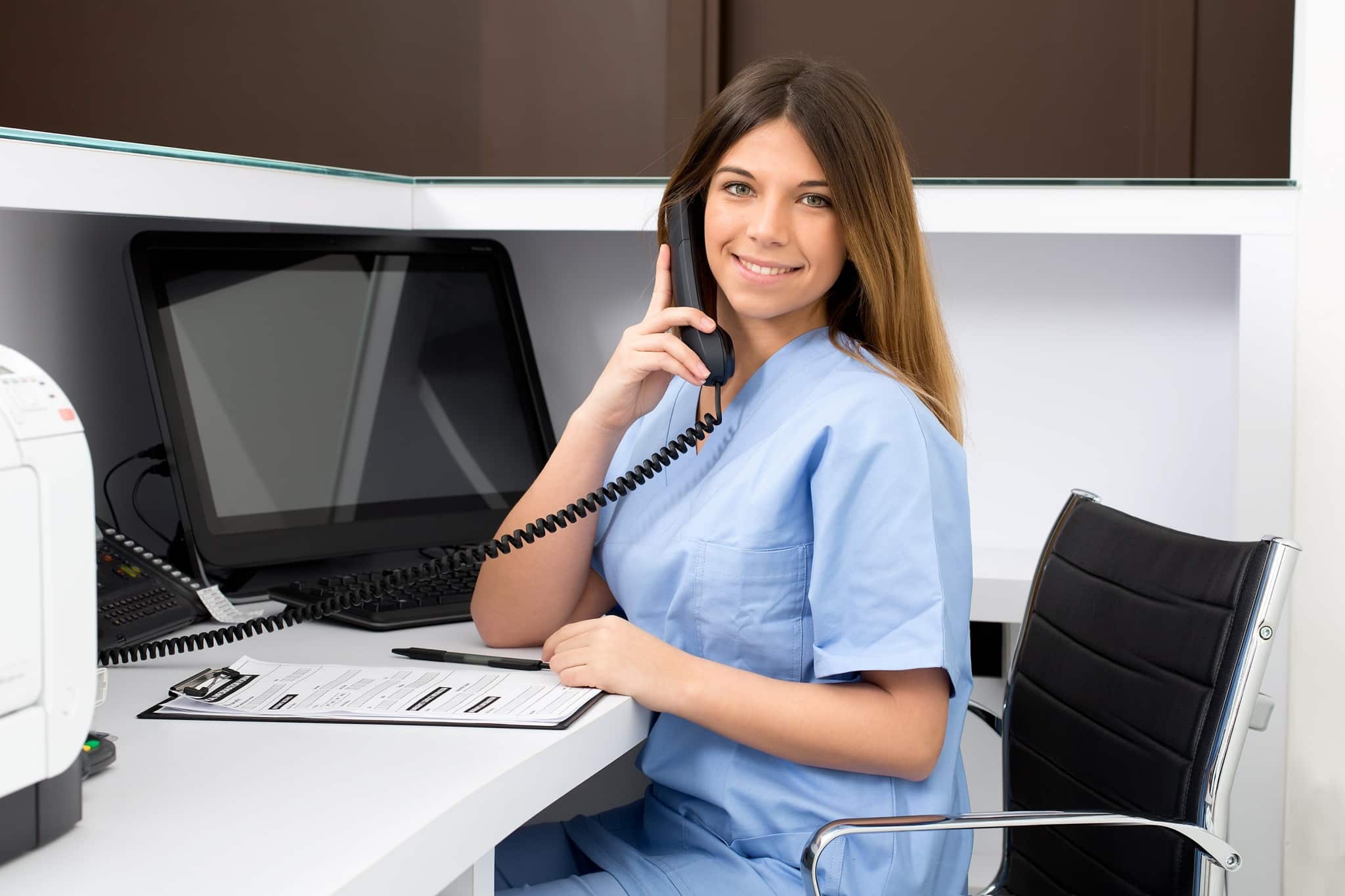 Medical receptionist smiling on the phone