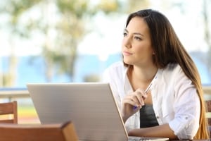 Mujer con un bolígrafo y una computadora portátil