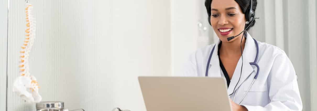 Medical professional using a headset and laptop