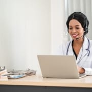 Medical professional using a headset and laptop