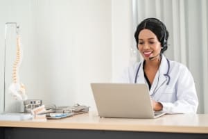 Medical professional using a headset and laptop