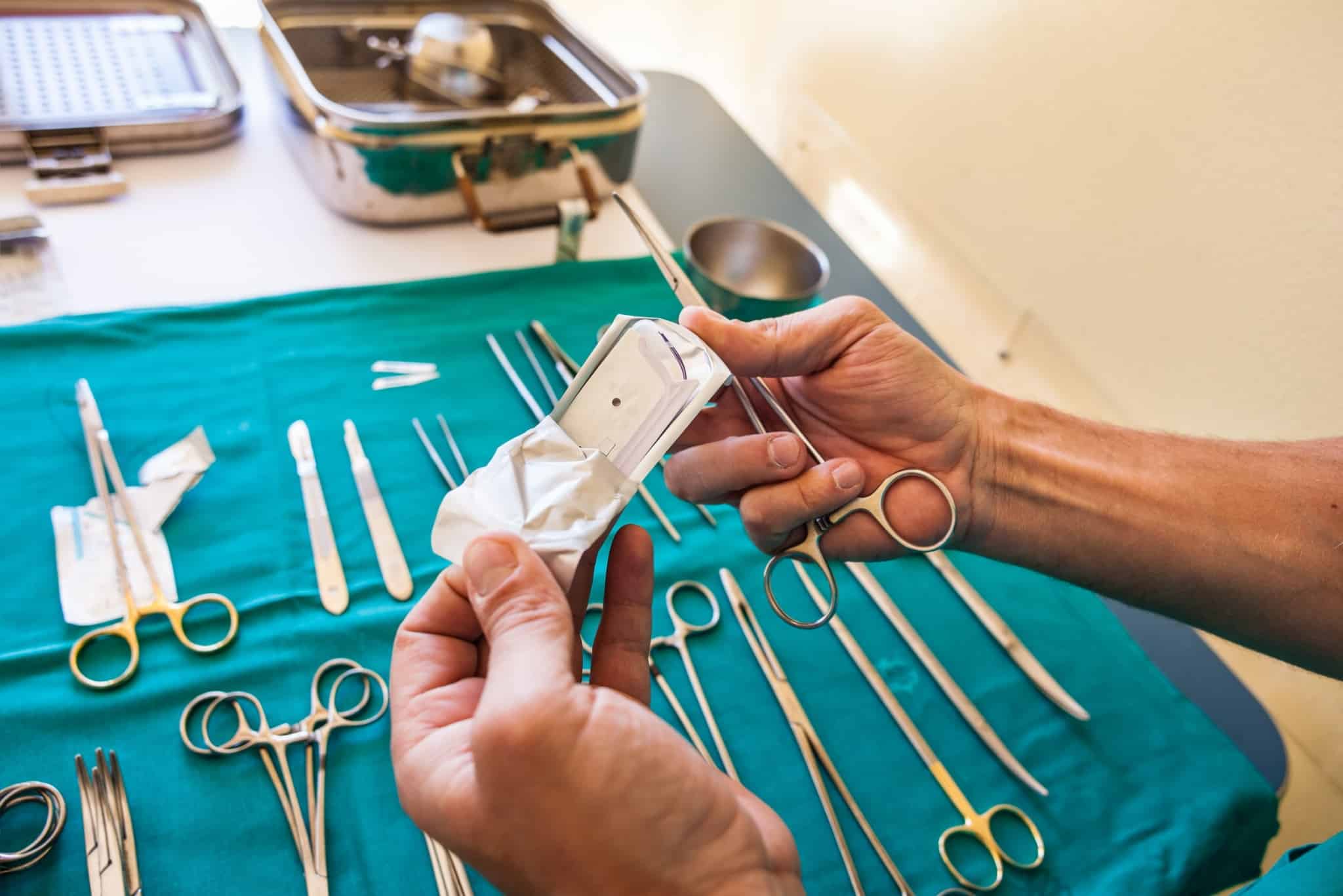 Hands of a surgeon holding surgical equipment