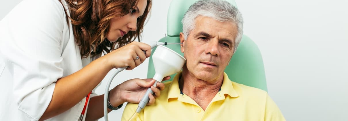 Healthcare professional irrigating a patient's ear