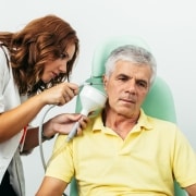 Profesional sanitario irrigando el oído de un paciente