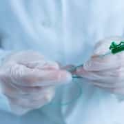 Gloved hands holding a catheter