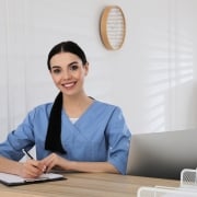 Young healthcare worker writing on a clipboard