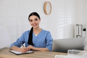 Joven trabajador de la salud escribiendo en un portapapeles