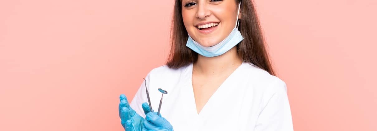 Smiling dental professional holding tools