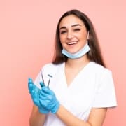 Smiling dental professional holding tools