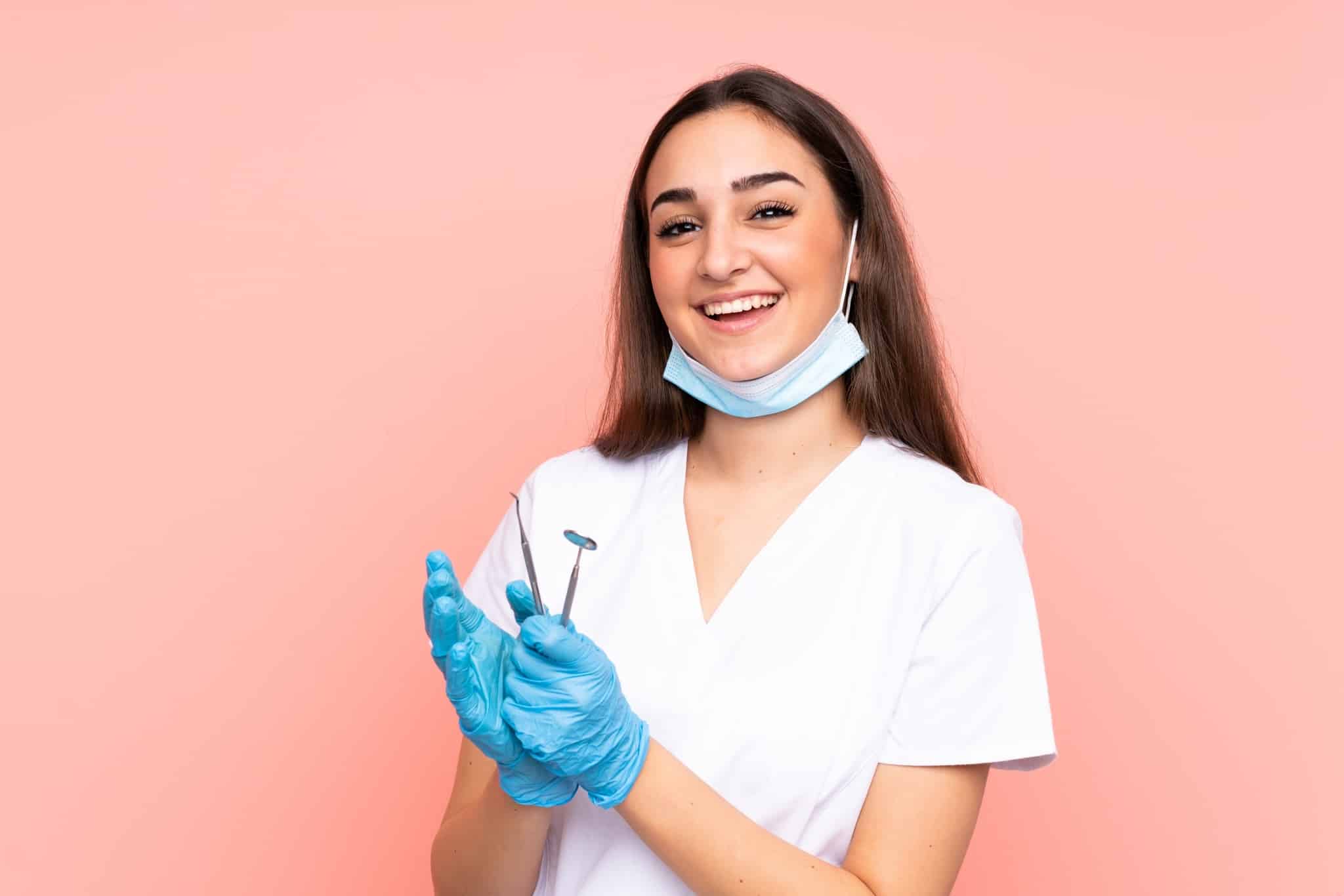 Smiling dental professional holding tools