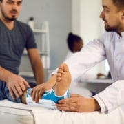 Profesional médico que examina el tobillo de un paciente