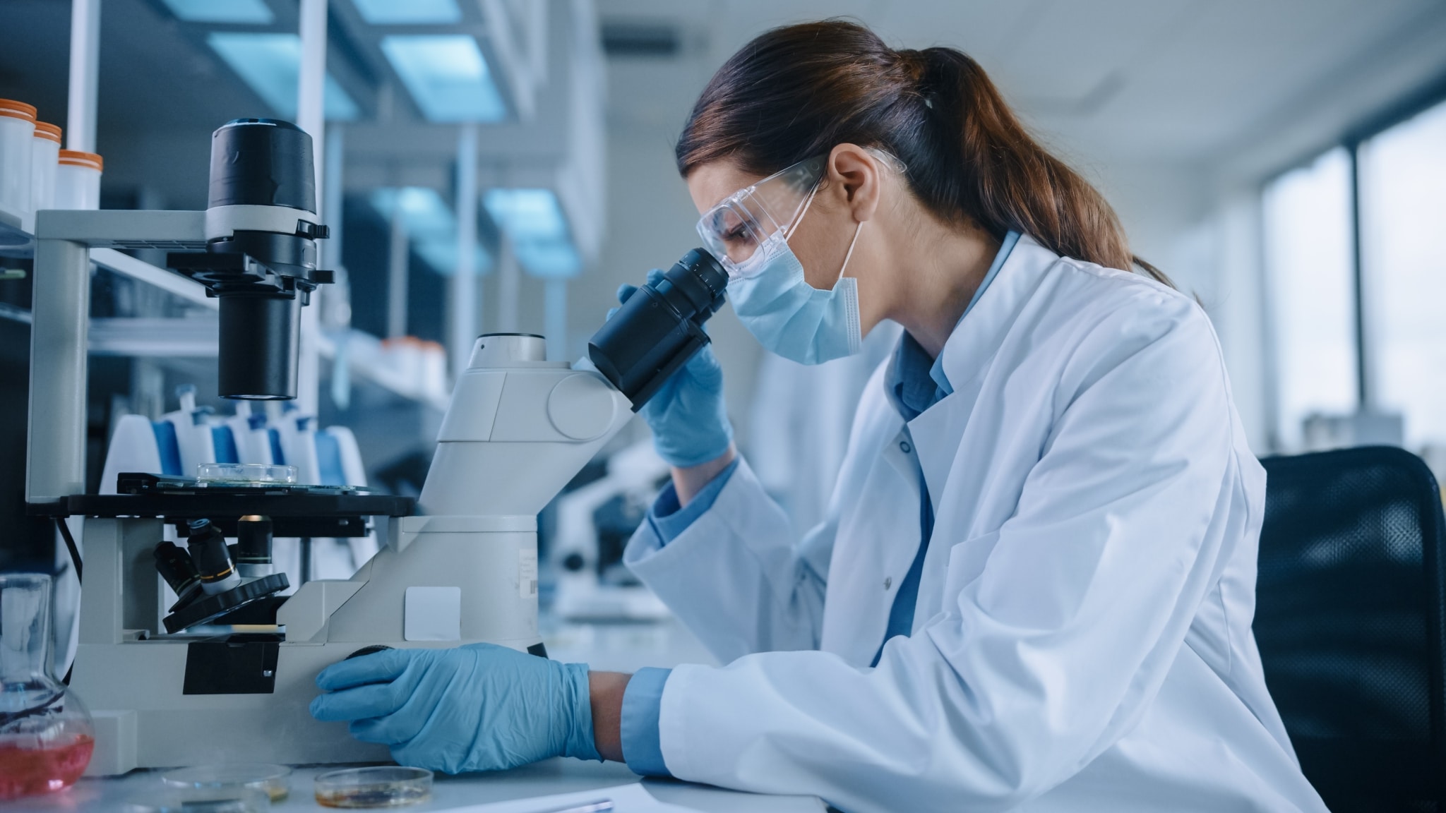 Female scientist looking through a microscope