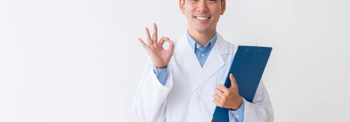 Asian man in a white coat holding a clipboard