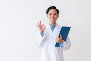Asian man in a white coat holding a clipboard