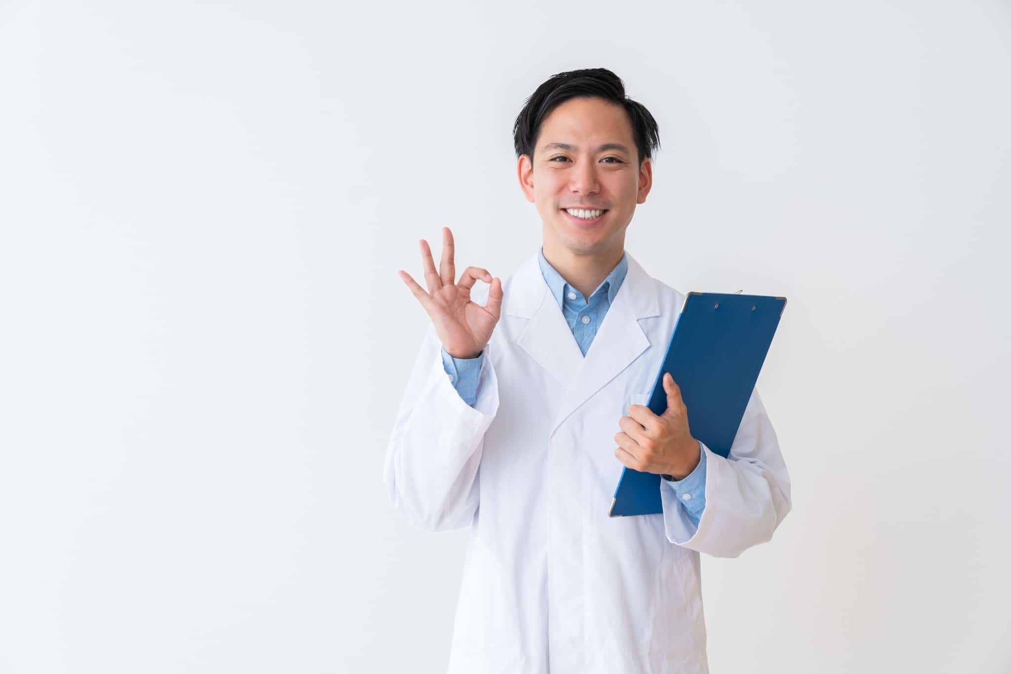 Asian man in a white coat holding a clipboard