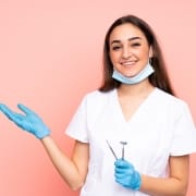 Female dental professional against a pink backdrop