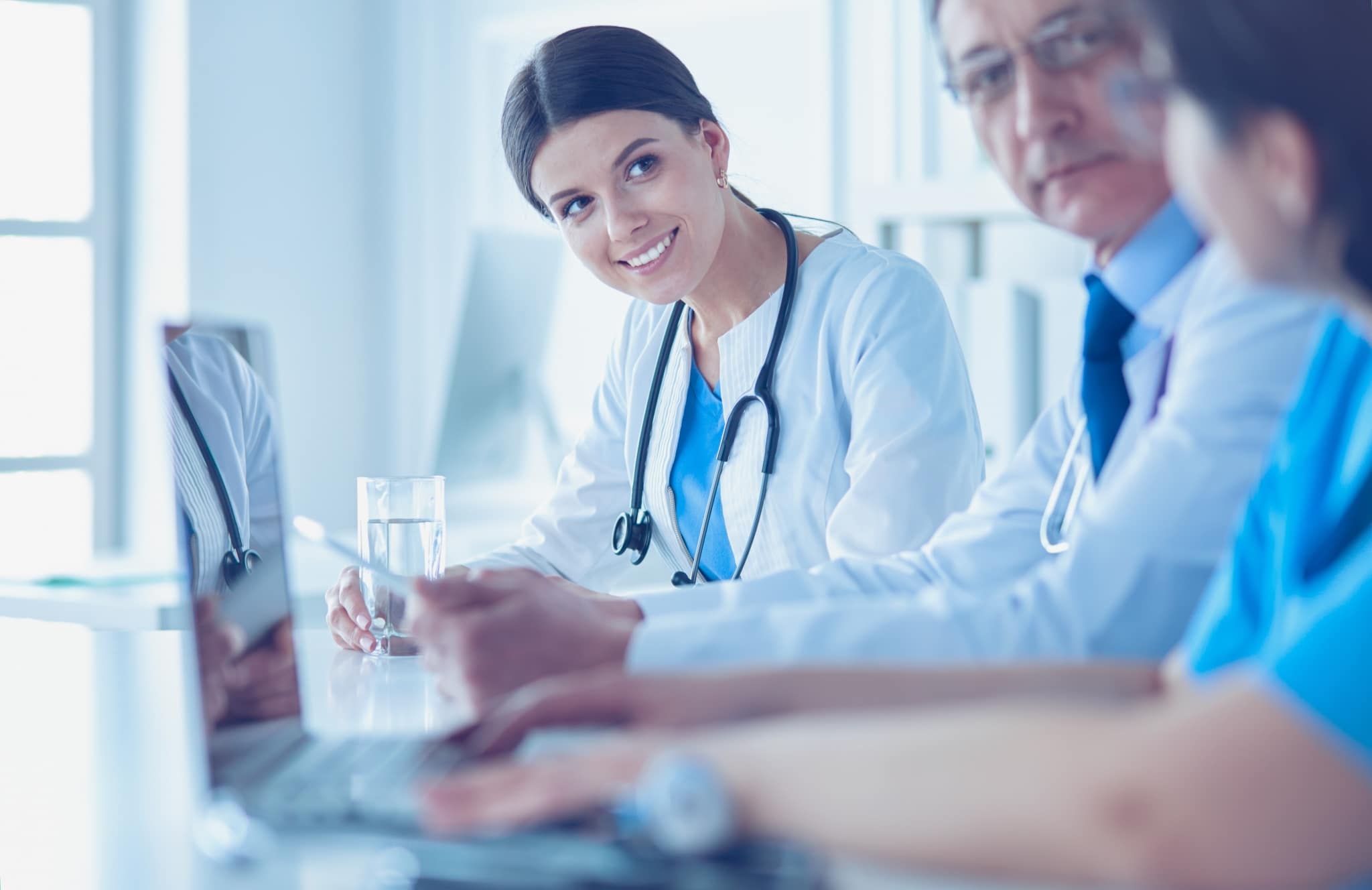 Smiling medical team using laptops