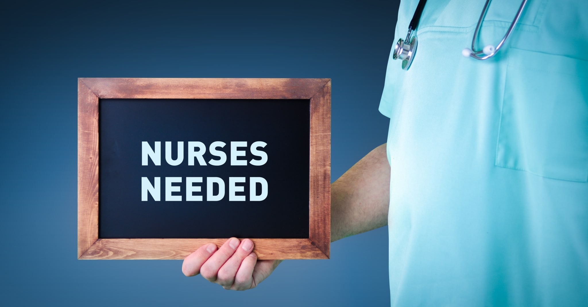 Nurse holding a sign that says nurses needed
