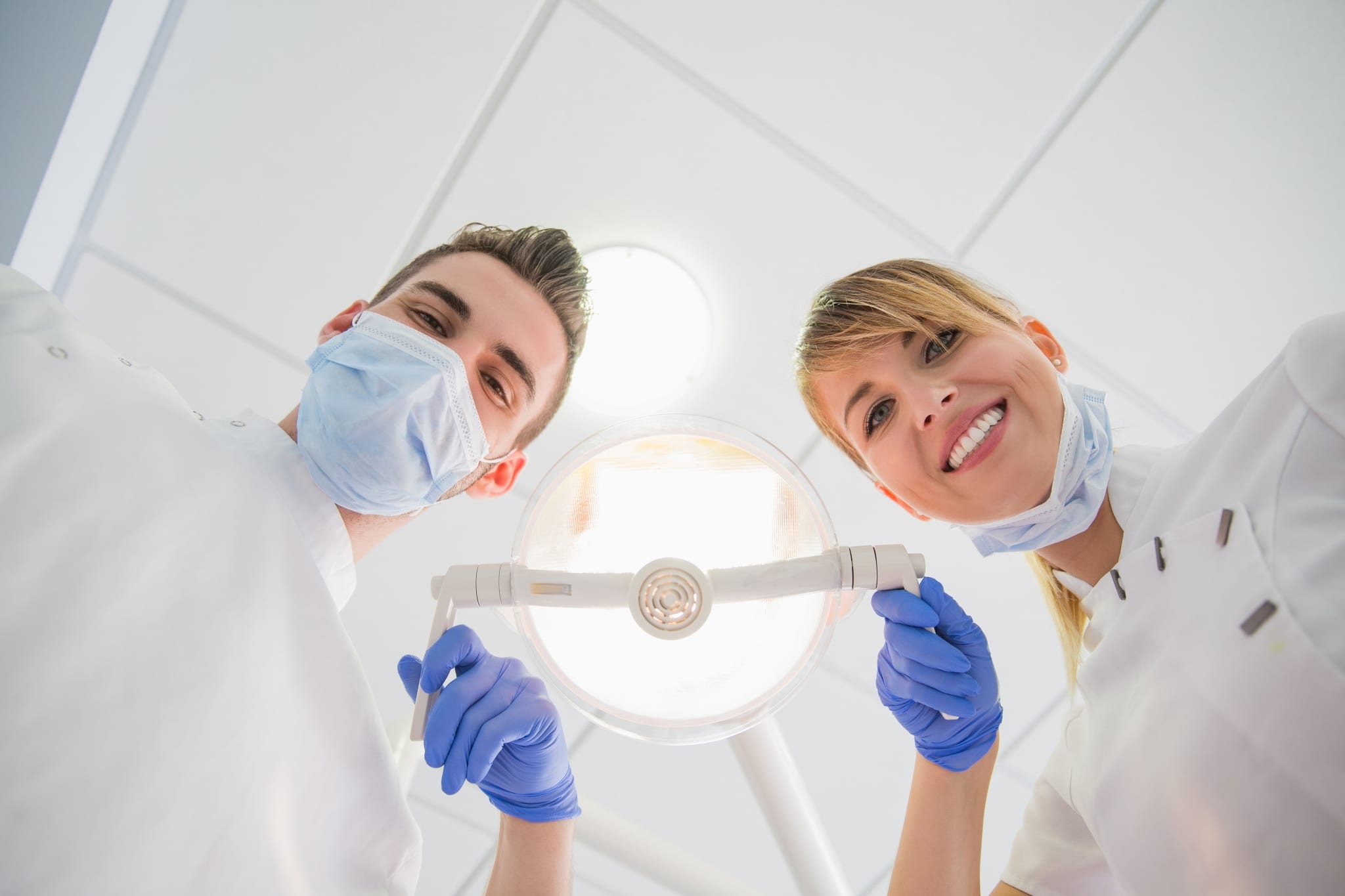 Patient looking up at two dental professionals