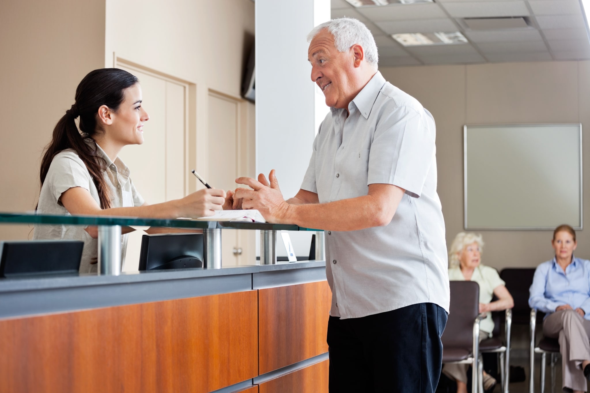 Medical receptionist with an older patient