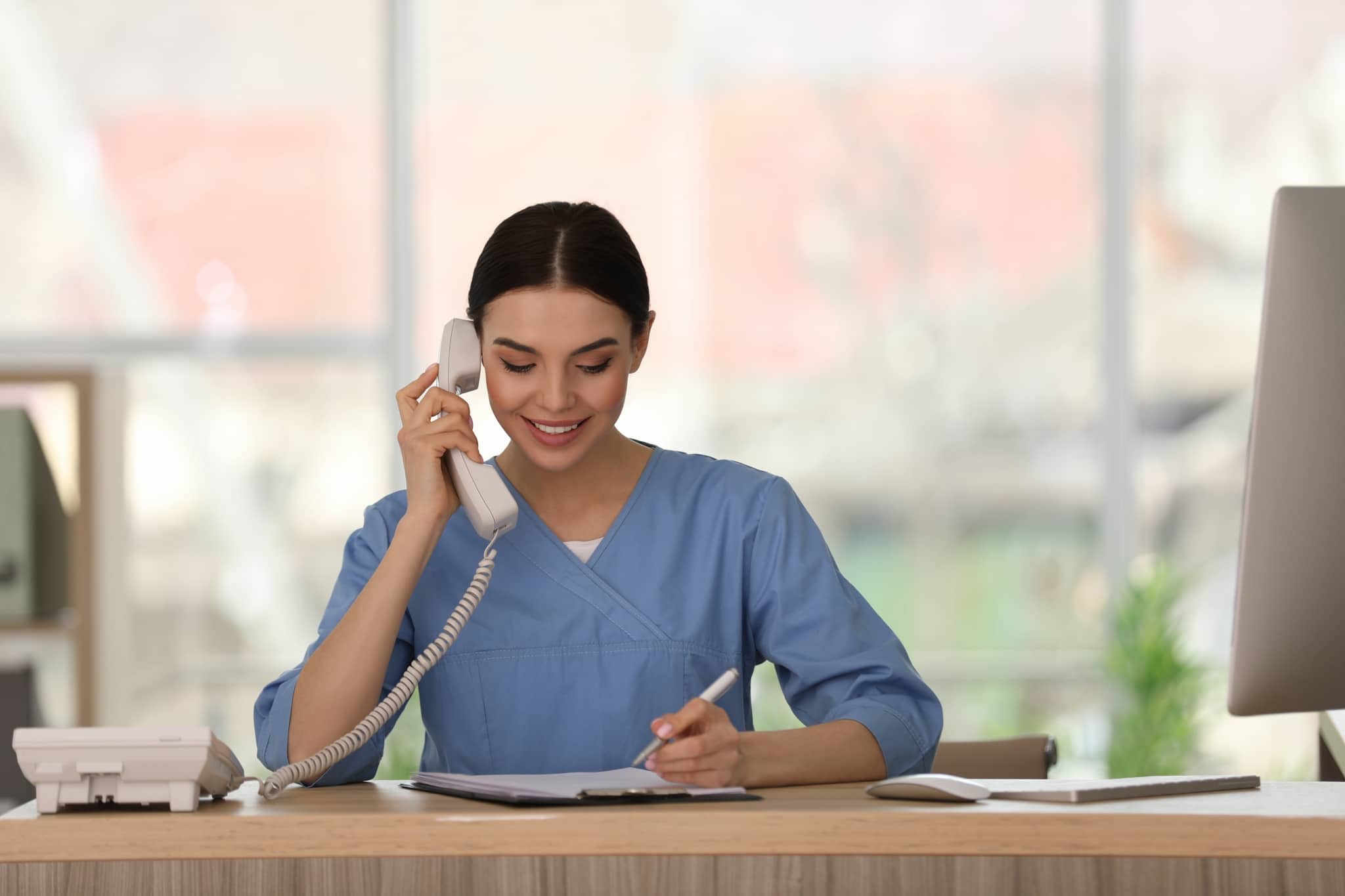 Smiling medical office administrator on the phone