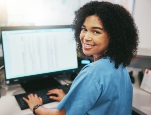 Smiling medical receptionist on the computer