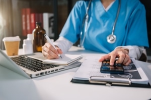 Close up of a medical professional using a calculator