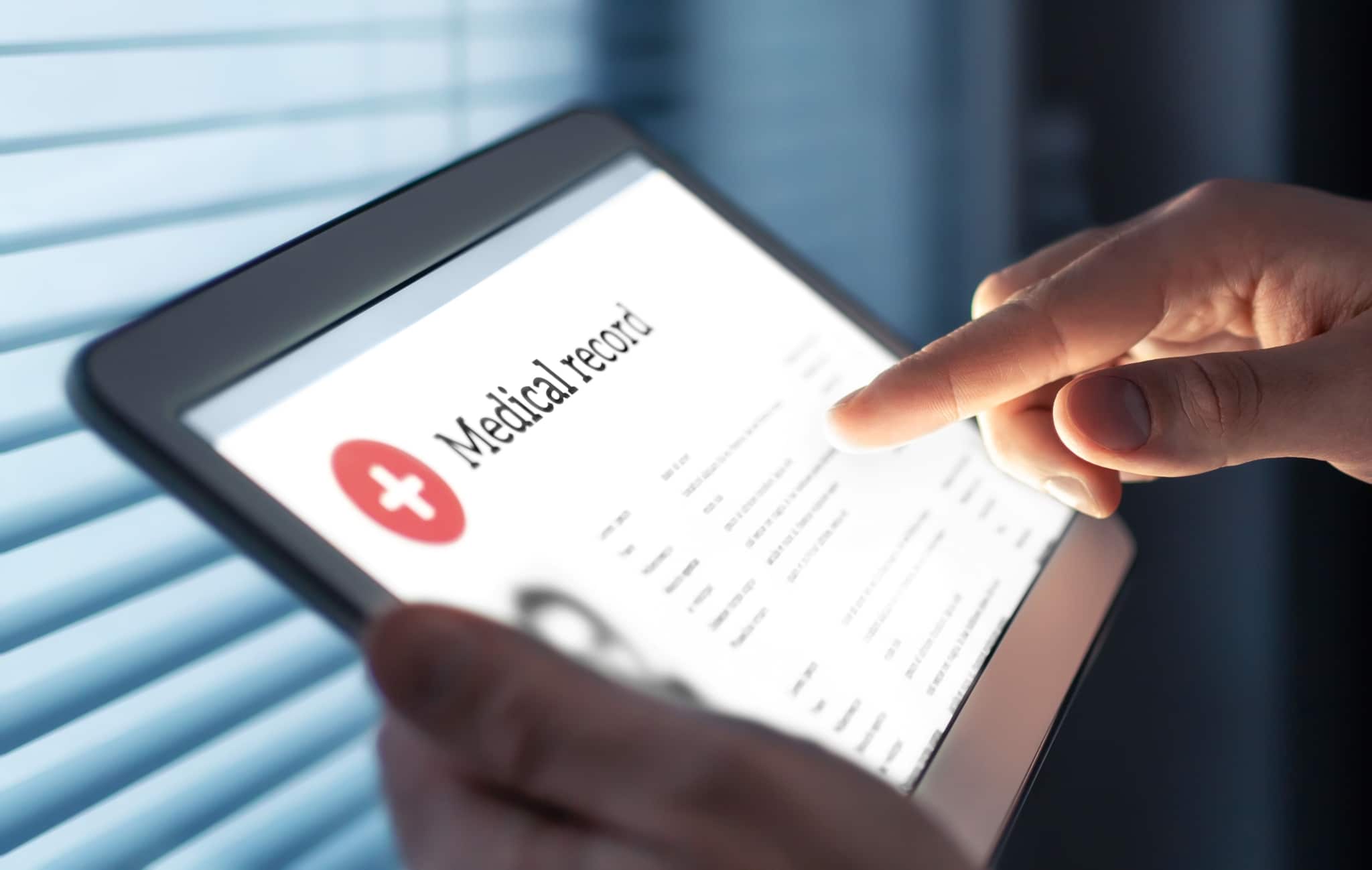 Close up of hands holding a tablet that says medical record