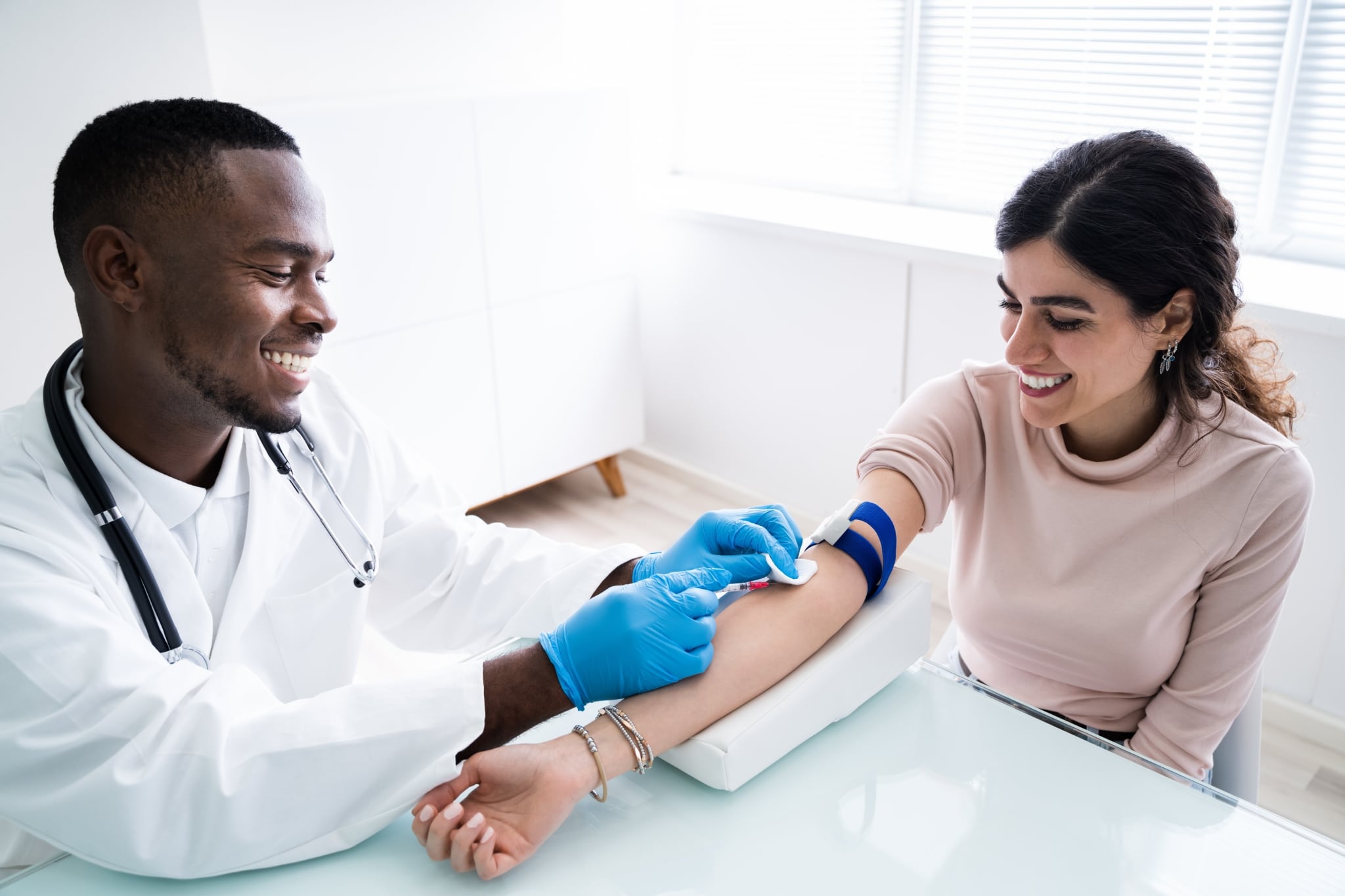 Phlebotomy technician drawing blood from a patient