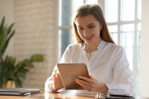 Smiling medical professional holding a tablet