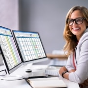 Smiling medical billing coder in front of a laptop