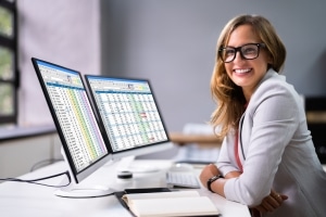 Smiling medical billing coder in front of a laptop