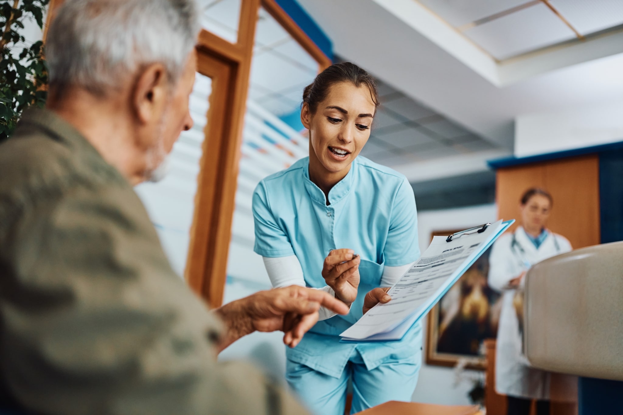 Medical professional helping an elderly patient with paperwork