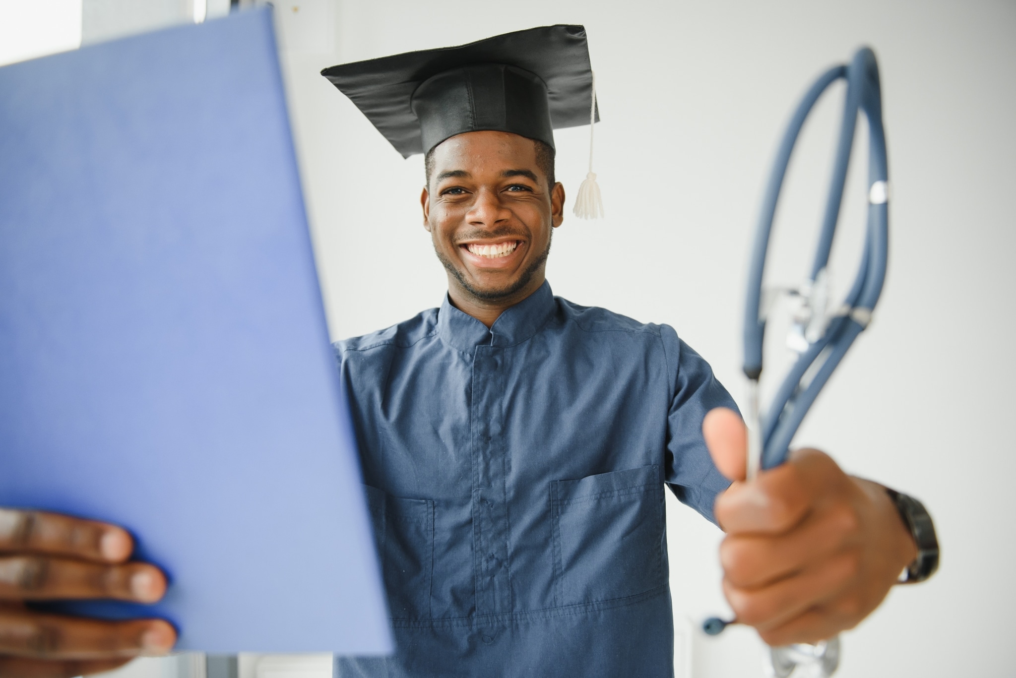 African-American medical graduate holding a stethoscope
