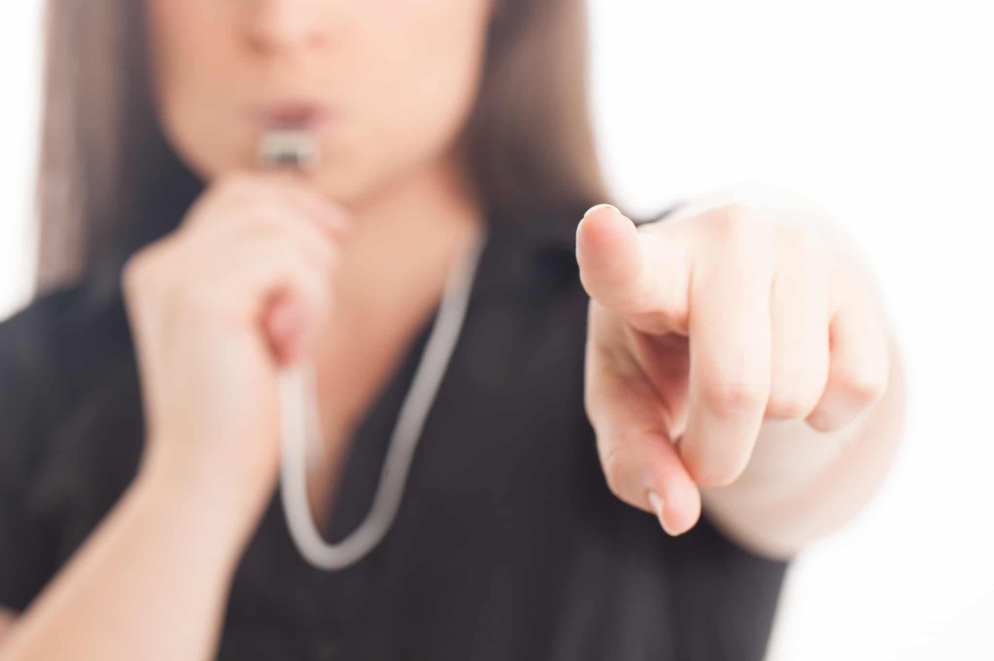 Close up of a woman blowing a whistle