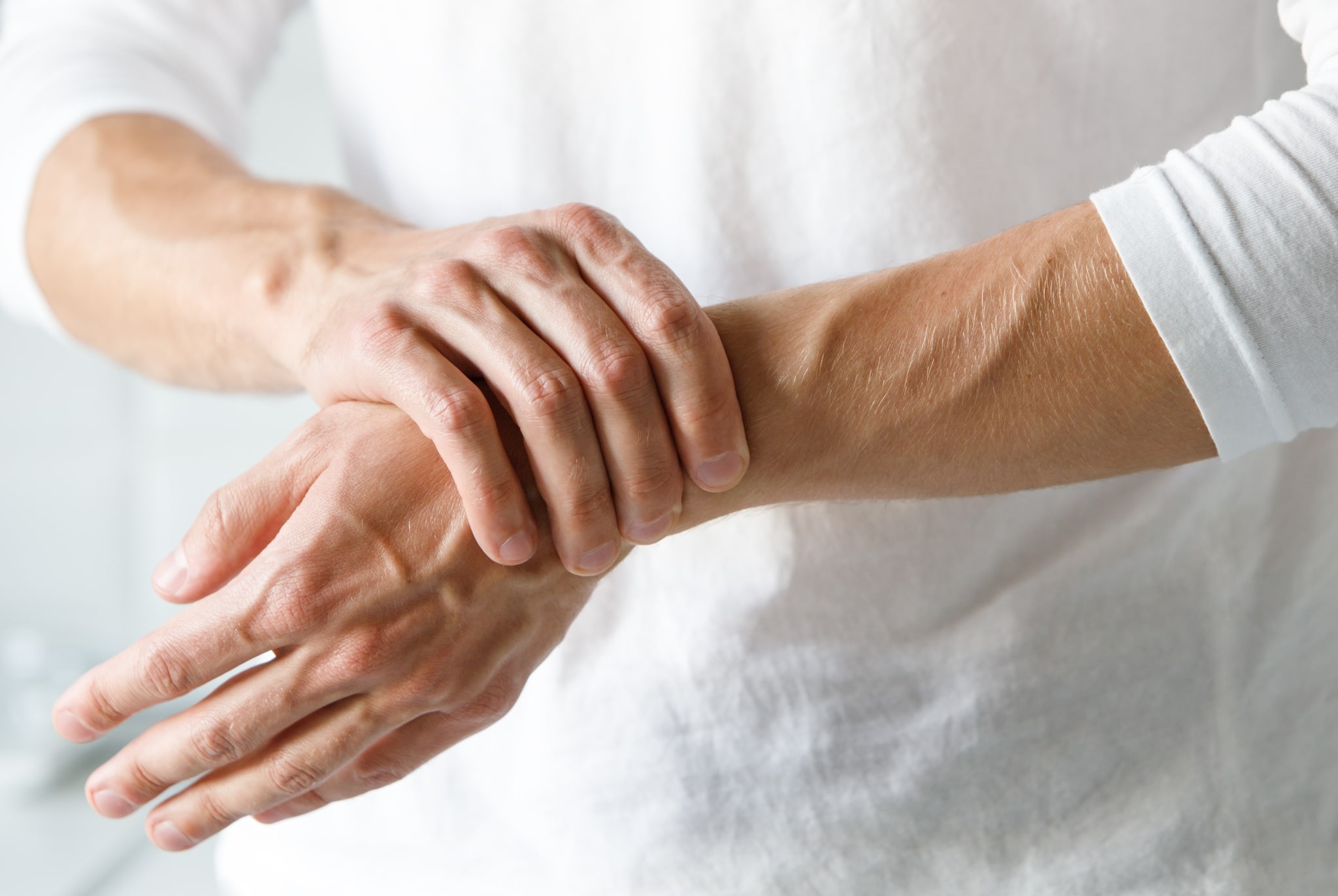 Close up of a patient with arthritis holding their wrist