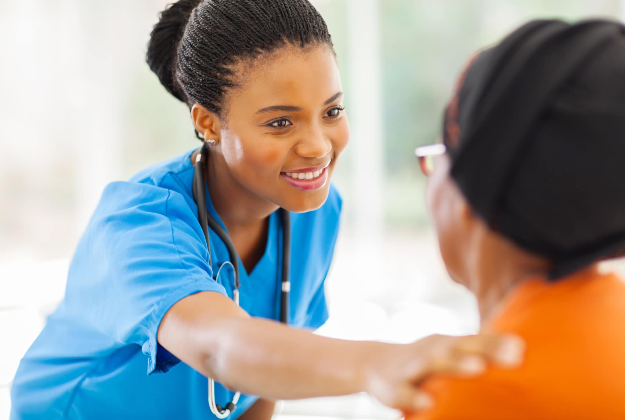African-American nurse reaching out to a patient