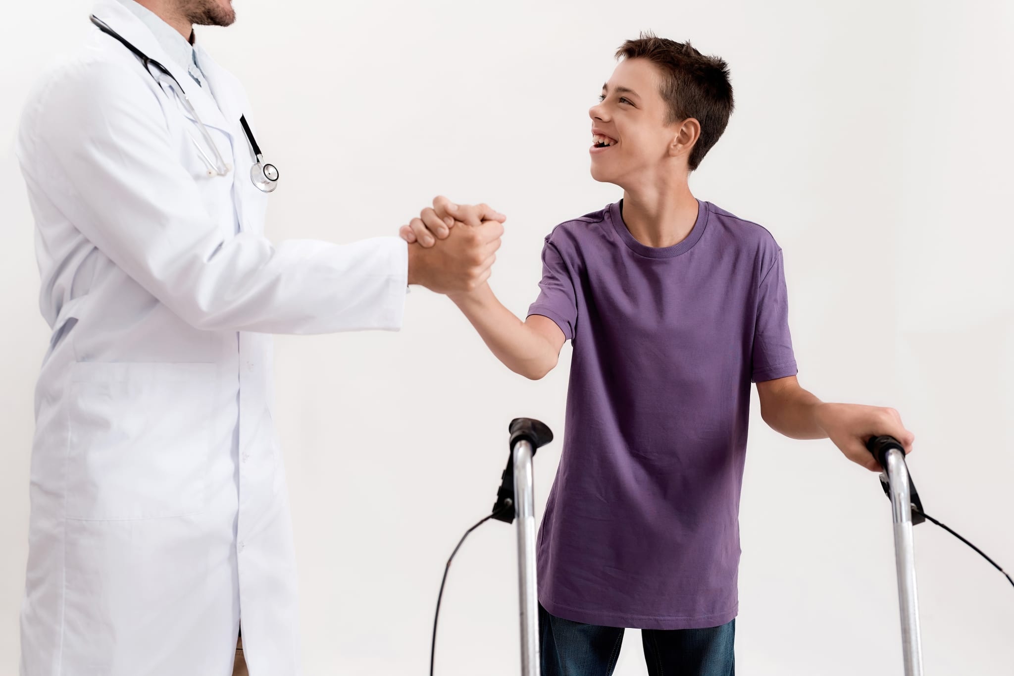 Young patient with cerebral palsy shaking the hand of a medical professional